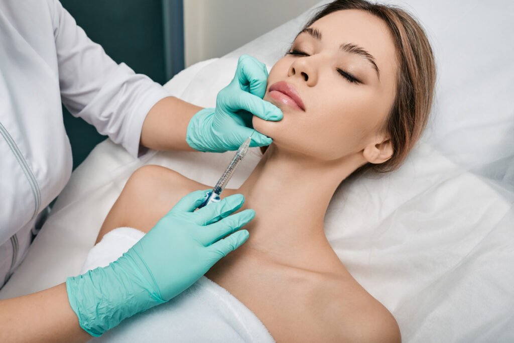 Woman getting cosmetic injectables in the chin for improved jawline contour