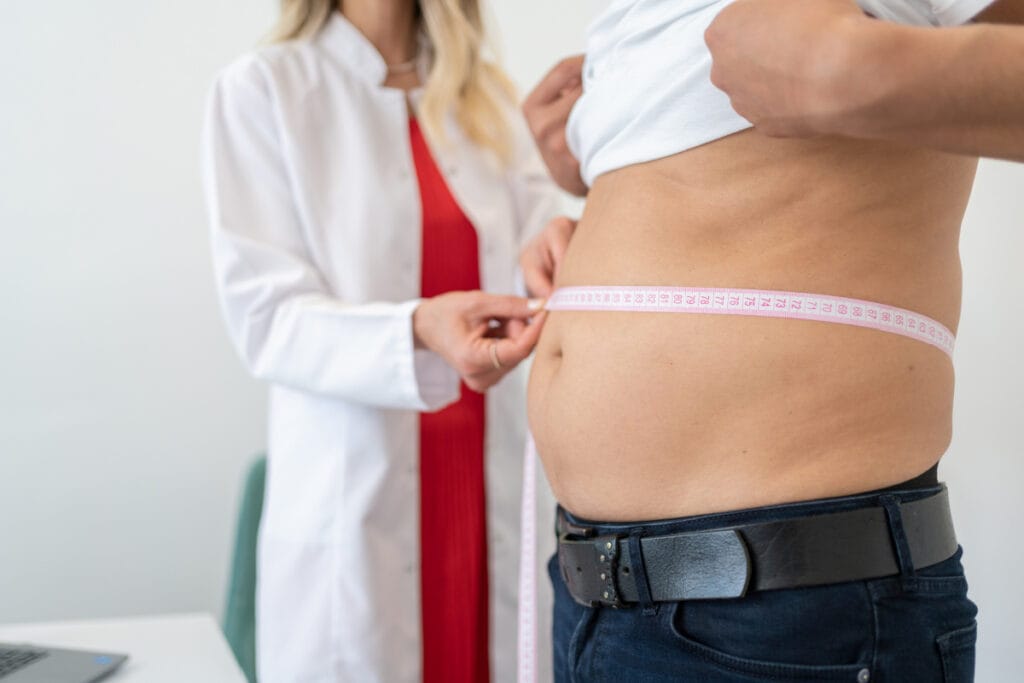 Man getting measurements taken during medical weight loss program check-in appointment